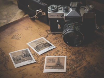 Alte Kamera auf einer Karte, daneben ein paar Polaroid-Bilder